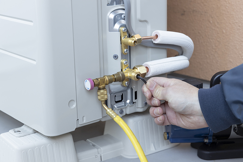 A man installing an air conditioner system during an HVAC installation appointment.