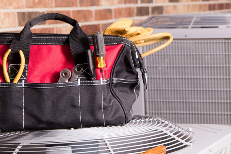 What to Expect During a Full HVAC System Installation. Tools on top of an air conditioning unit.